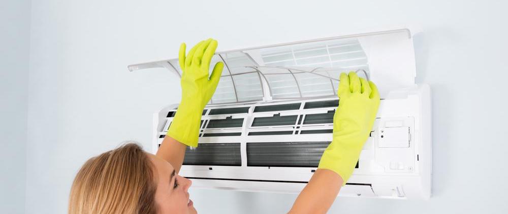 lady cleaning AC unit