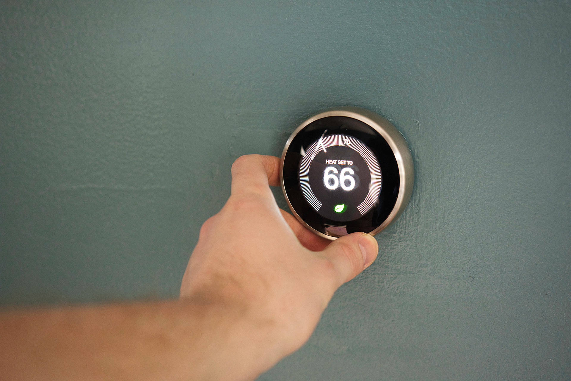 person turning up thermostat